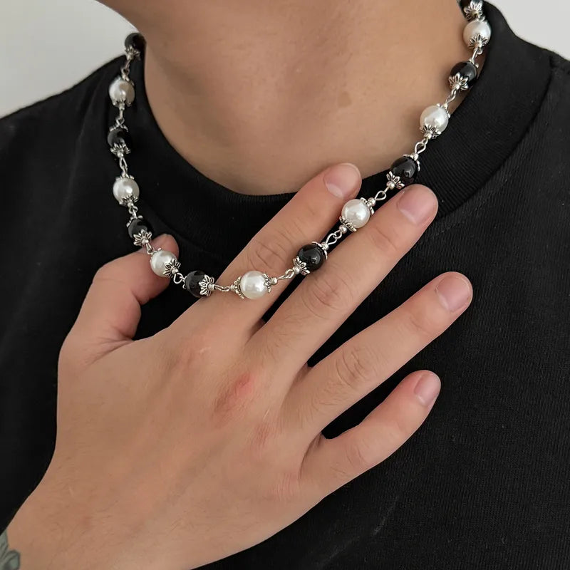 Close-up of the black and white beaded necklace worn by a man