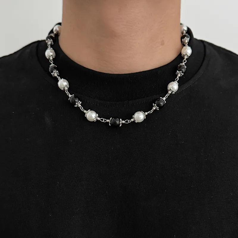 Men's black and white beaded necklace worn with a black shirt