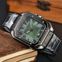 A rugged black metal watch with a green dial and Roman numeral hour markers, resting on a stack of vintage books against a dark wooden background.