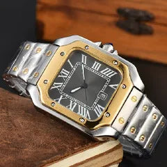 A two-tone stainless steel and gold-tone watch with a black dial and Roman numeral hour markers, resting on a wooden surface.