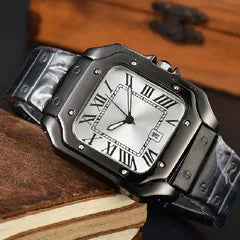 A close-up of a black metal watch with a silver dial and Roman numeral hour markers, resting on a stack of old books against a wooden background.