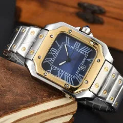 A men's stainless steel and gold-tone watch with a blue dial and Roman numeral hour markers, resting on a brown leather-bound book.