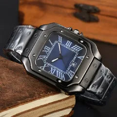 A rugged black metal watch with a blue dial and Roman numeral hour markers, resting on a brown leather-bound book with a wooden surface in the background.