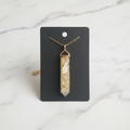 Clear gold resin pendant on white marble