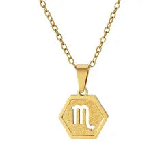 A gold hexagonal pendant necklace featuring the Libra zodiac symbol, displayed on a clean white background.