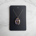 Ocean God Teardrop resin necklace on marble background