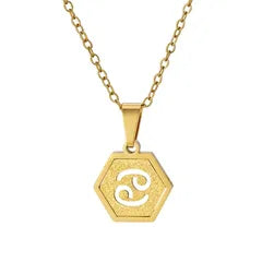A gold hexagonal pendant necklace featuring an engraved zodiac symbol, suspended from a gold chain against a plain white background.