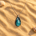 Ocean God necklace directly on sand