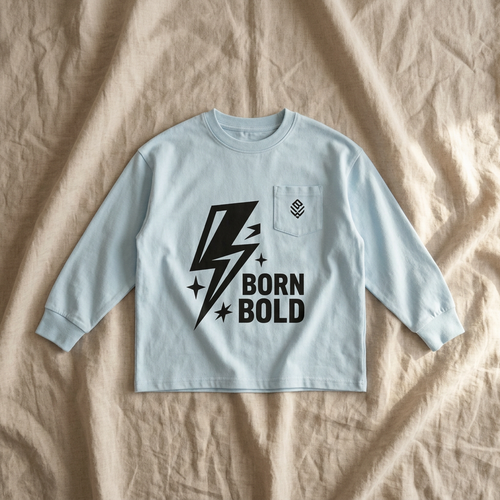 Pale-blue Born Bold T-shirt on linen bedsheets