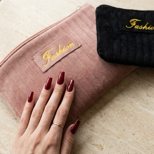 Pink and black makeup bags with burgundy nails