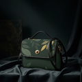 Promotional hero shot of the dark green leaf bag on dark silk