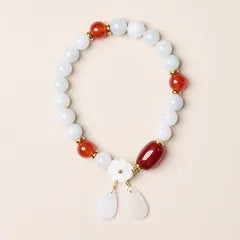 Pale beaded bracelet with red accent beads