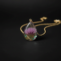 Small teardrop clear resin with purple thistle