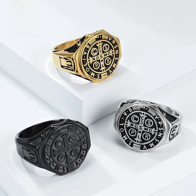 Three rings in gold, black, and silver on a white surface